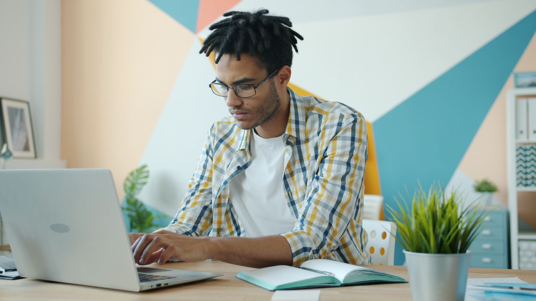 focused young professional working on laptop indoors
