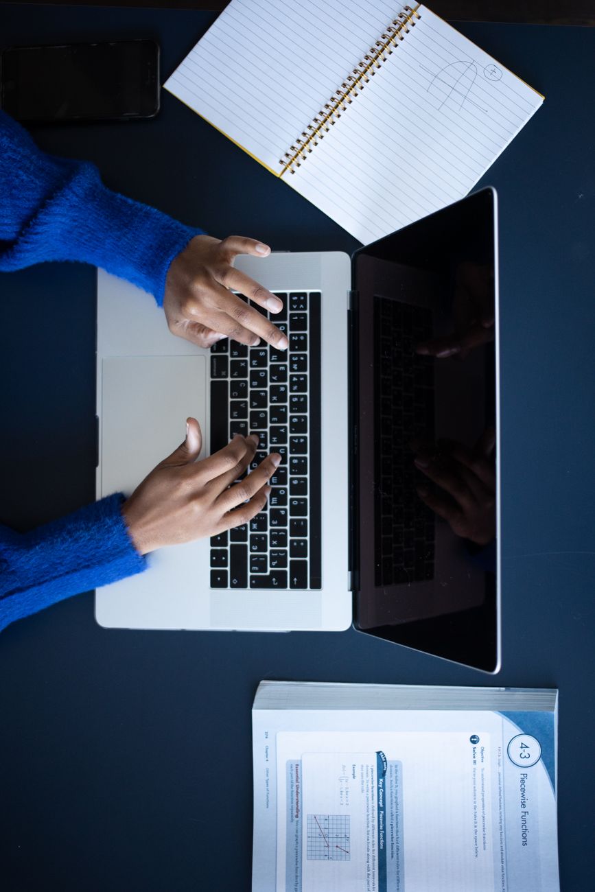woman typing on laptop keyboard at workspace
