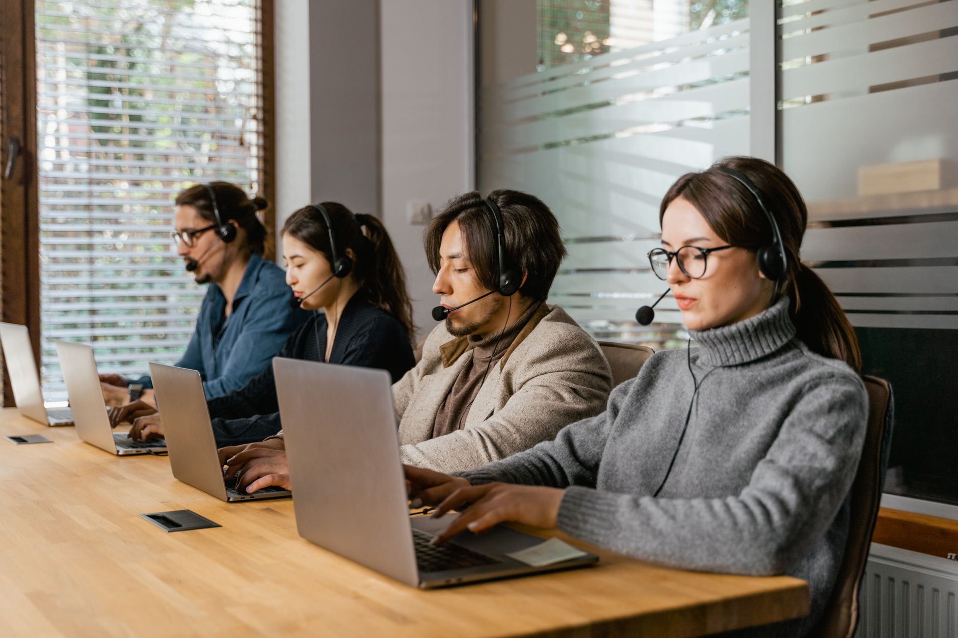 people working in an office with their laptops